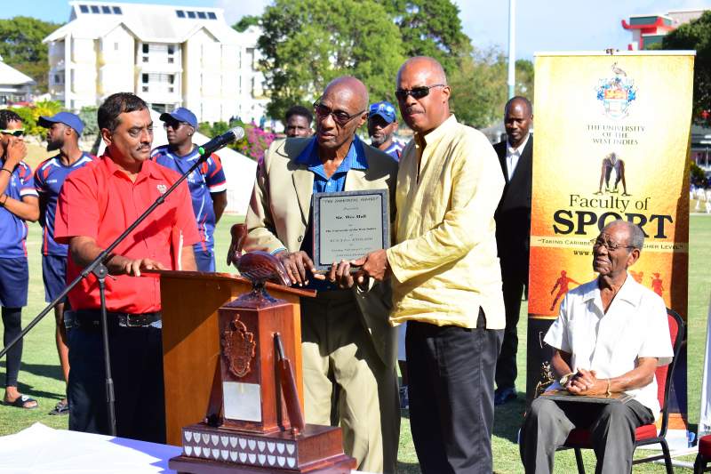 Professor Sir Hilary Beckles presents Sir Wes Hall with a Tribute plaque from The UWI