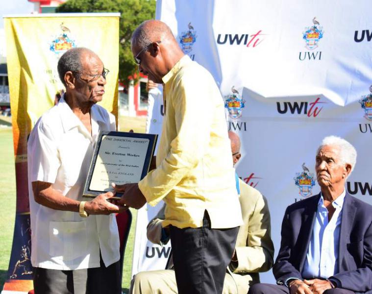 Professor Sir Hilary Beckles presents Sir Everton Weekes with a Tribute plaque from The UWI