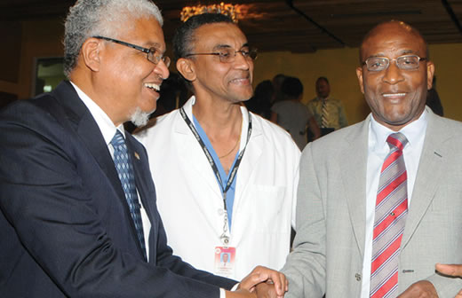 Prof. E. Nigel Harris (left), (former) Vice-Chancellor of The University of the West Indies (UWI), congratulates Prof. Joseph Frederick (right), Director, Hugh Wynter Fertility Management Unit (HWFMU) at the launch of the UWI’s Single Virtual University Space (SVUS) and Telemedicine Pilot at the HWFMU, Mona. At centre is Dr. Shaun Wynter, Consultant, HWFMU.