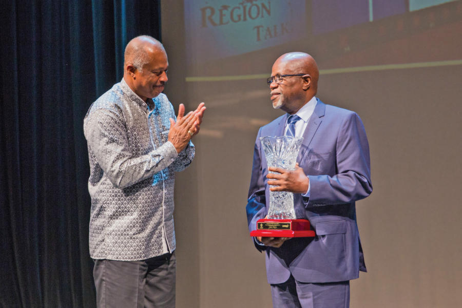 Professor Sir Hilary Beckles on stage with Mr Julian Rogers as Rogers accepts his inaugural UWItv award.